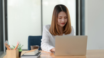 Wall Mural - Close up view of female entrepreneur working while sitting at her working place