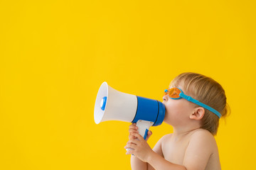 Canvas Print - Portrait of happy child speaking by megaphone