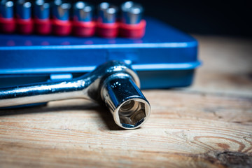 A socket wrench and its inserts on a blue tool box