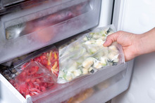 Freezer And Frozen Vegetables, A Person Taking Food From The Freezer