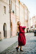 © Serhii - Portrait of young stylish beautiful girl in a red dress with bouquet of flowers running on the street, smiling enjoy her weekends. Summer, sunny, trendy, lifestyle.