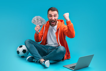 Young attractive bearded man celebrating victory after betting at bookmaker's website