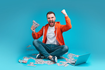 Wall Mural - Young attractive bearded man celebrating victory after betting at bookmaker's website