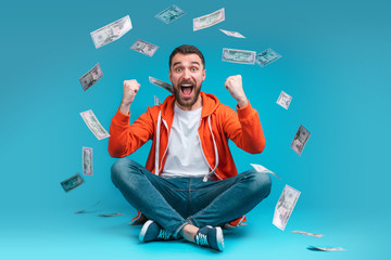 Wall Mural - Young attractive bearded man celebrating victory after betting at bookmaker's website