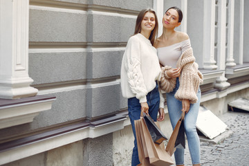 Beautiful girls in a summer city. Ladies with shopping bags