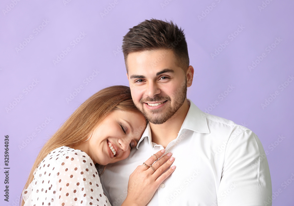 Happy young couple on color background