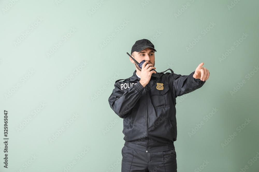 Male police officer on color background