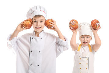 Cute little chefs with pastry on white background