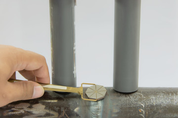 Human hand holding the Pie Field Indicator and place on the welding between two Permanent magnet. Pie gauge is a device used as an aid in determining the direction of magnetic field.