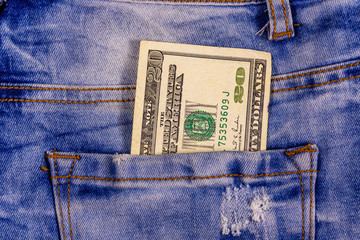 American twenty dollar banknote in a pocket of blue jeans