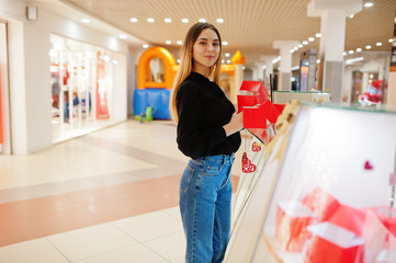 Wall Mural - Portrait of young caucasian female woman seller hold red gift boxes. Small business of candy souvenirs shop.