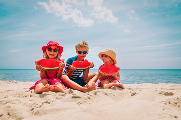 Wall Mural - happy cute kids eating watermelon at beach