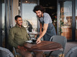 © StratfordProductions - Cheerful young man serving afro-american customer at coffee shop