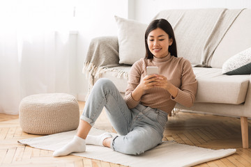 Modern girl checking emails on smartphone at home