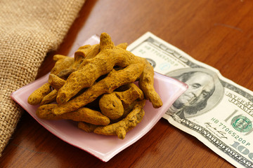 Wall Mural - 100 usd banknote and dry ginger and turmeric roots on a ground,