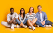 © Prostock-studio - Happy students posing over yellow studio background
