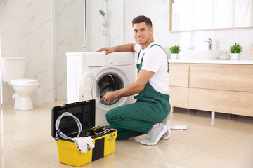 Poster - Professional plumber repairing washing machine in bathroom