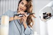 © Yakobchuk Olena - Happy pretty woman is using curling iron at home