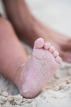 A Baby Feet Covered With White Fine Sand