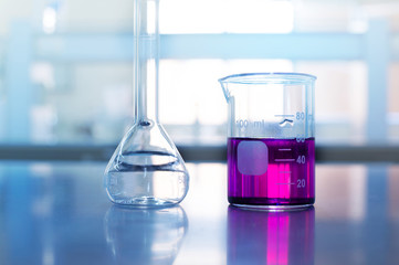 Wall Mural - beaker and flask on science table on blue chemistry laboratory background