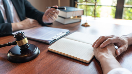 Lawyer working with client discussing contract papers with brass scale about legal legislation in courtroom, consulting to help their customer