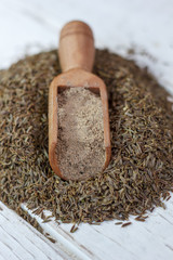 Sticker - Grounded cumin seeds in a wooden spoon over the seeds