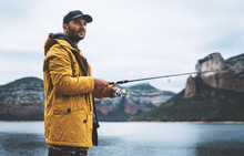 Beard Fisherman Hold In Hand Fishing Rod, Man Enjoy Hobby Sport On Mountain River, Person Catch Fish On Background Nature Blue Sky, Fishery Concept