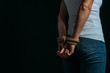 Partial view of victim hands tied with rope isolated on black