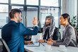 © LIGHTFIELD STUDIOS - positive multicultural business partners giving highfive on meeting with translator in office