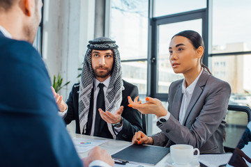 multicultural businesspeople talking on meeting with translator in office