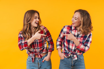 Wall Mural - Image of two young girls smiling and pointing fingers at each other