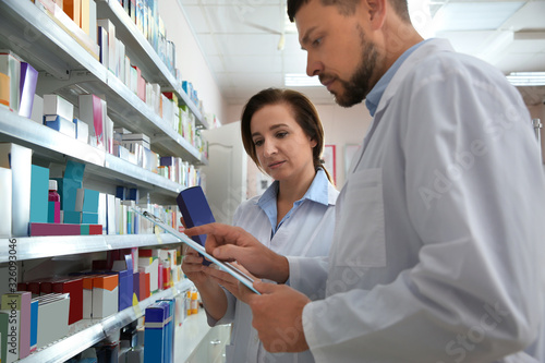 Cuadros en Lienzo Professional pharmacists near shelves with medicines in modern drugstore