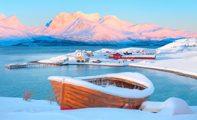Wall Mural - red wooden boat covered with layers of snow - beautiful winter landscape with snow covered red house
