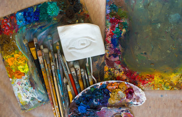 Workplace painter palette with colors and brushes. Palette of colors, creative disorder, art.