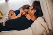 © Maskot - Portrait of smiling girl with mature father lying on bed