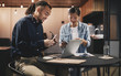 © Flamingo Images - Smiling young businesspeople working at a table in an office