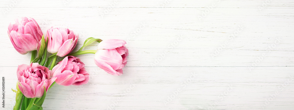 Bunch of pink tulips on white wooden background with copy space. Banner with spring flowers. Top view. - obrazy, fototapety, plakaty 