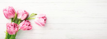 Bunch Of Pink Tulips On White Wooden Background With Copy Space. Banner With Spring Flowers. Top View.