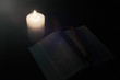 © Konstiantyn Zap - Burning candle and opened bible, book. The concept of faith in God, Christianity, religion.