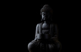 Meditating Buddha Statue isolated on black background. Copy space.