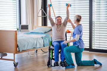 Wall Mural - A healthcare worker and senior patient in hospital, physiotherapy.