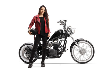 Wall Mural - Young woman holding a helmet and standing next to a custom motorcycle