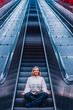 © kohanova1991 - Portrait of calm woman doing yoga meditation on escalator at subway station. Underground in Stockholm.