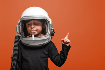 small child wants to fly an in space wearing an astronaut helmet