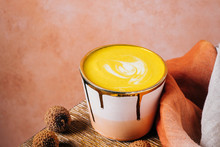 Golden Milk Latte In Pink And Gold Cup With Tumeric And Ginger