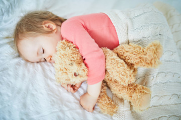 Wall Mural - Adorable baby girl sleeping with her favorite toy