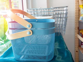 Empty modern blue metal shopping basket on table in the shop.