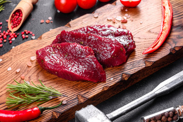 Fresh Raw Beef steak Mignon, with salt, peppercorns, thyme, tomatoes