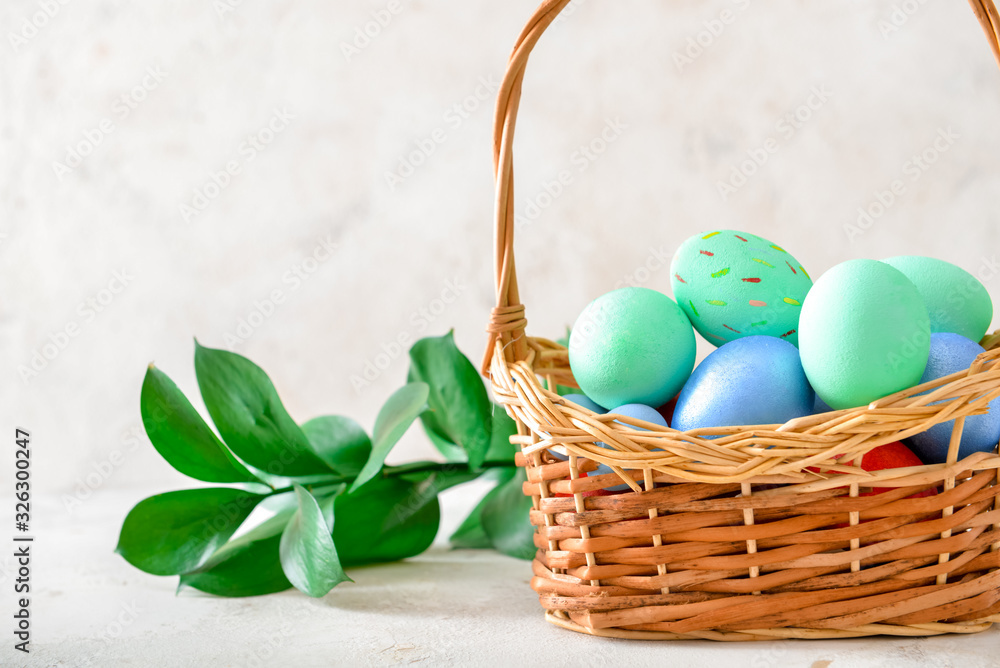 Basket with beautiful Easter eggs on white background