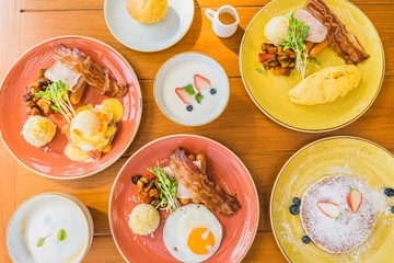 Wall Mural - Fried egg with eggs benedict and omelette around bacaon ham sausage in plate